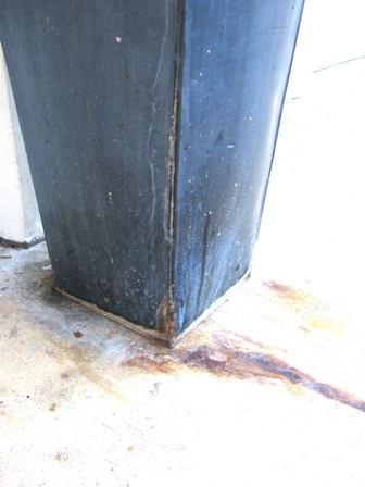 Details of tippy leaking metal planter